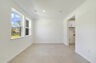 room with large windows and access to the foyer