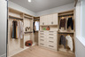 walk-in closet with wood floors, built-in drawers & shelves, and window