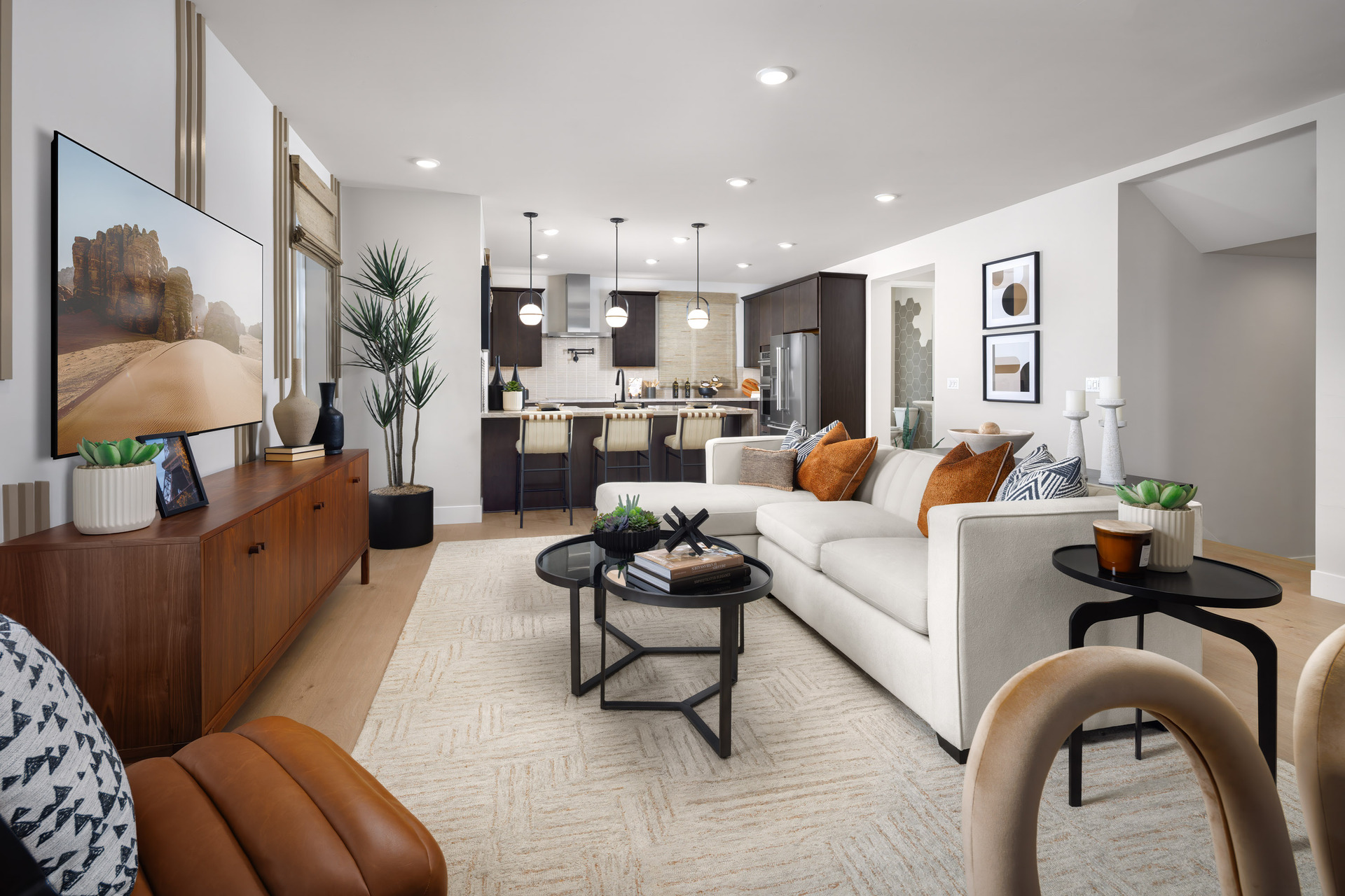 great room with white sofa, black coffee & side table, and wood console table under television