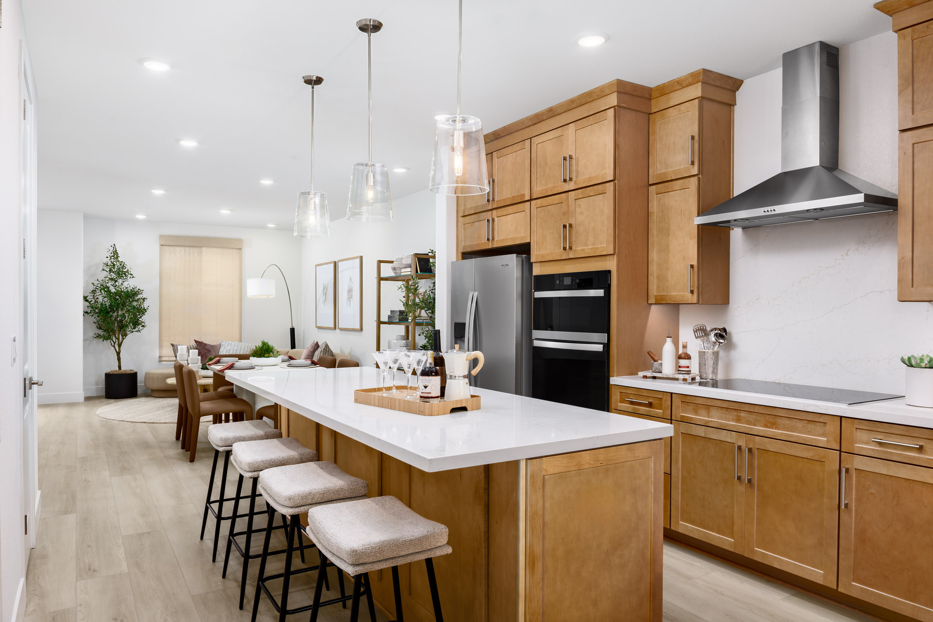 kitchen with light wood cabinets, white counters, island, and stainless-steel hood above stove