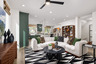 great room with black & white patterned area rug, white sectional sofa with green pillows, and round black coffee table