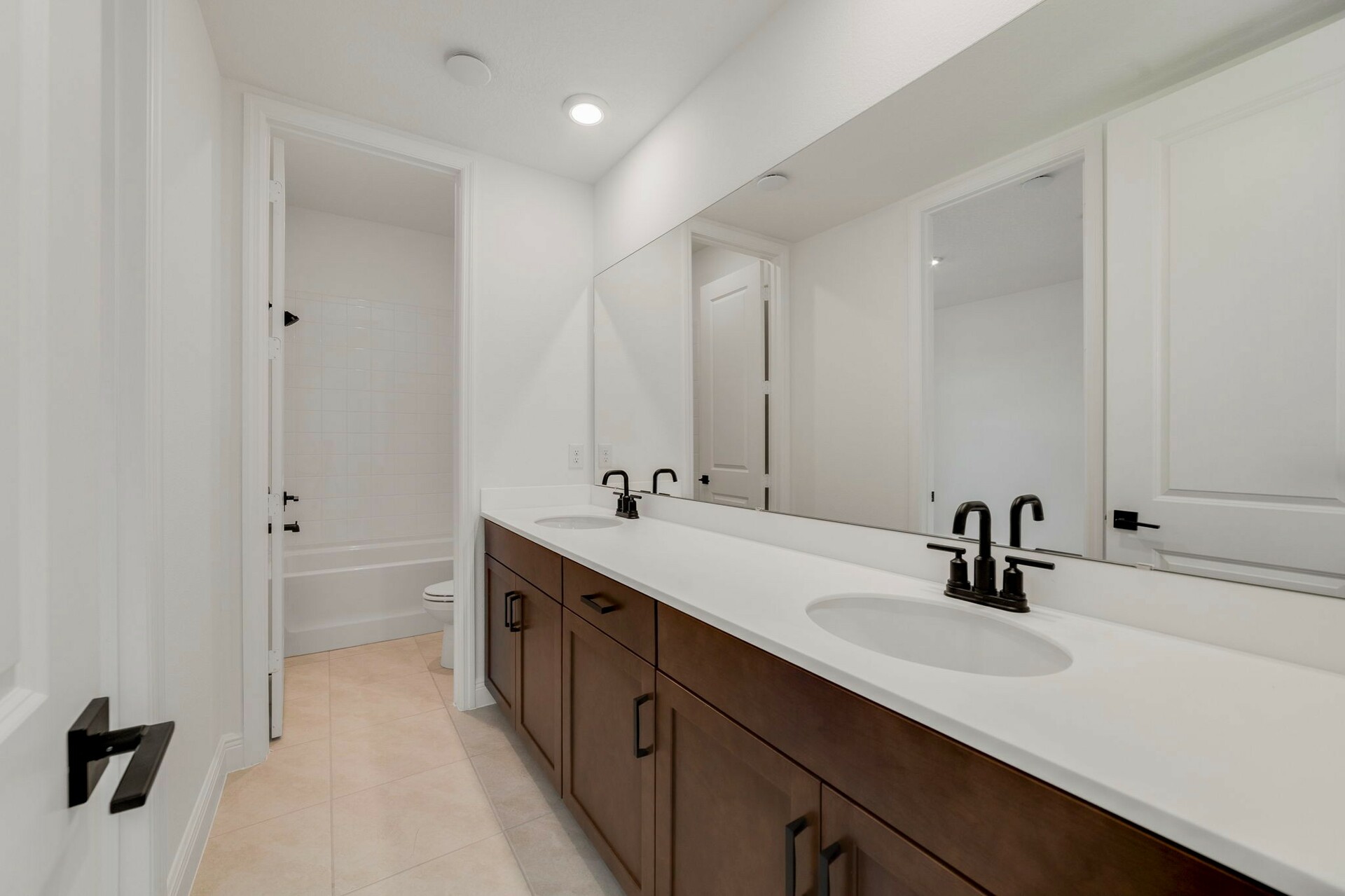 second bathroom with dual sinks and brown cabinets