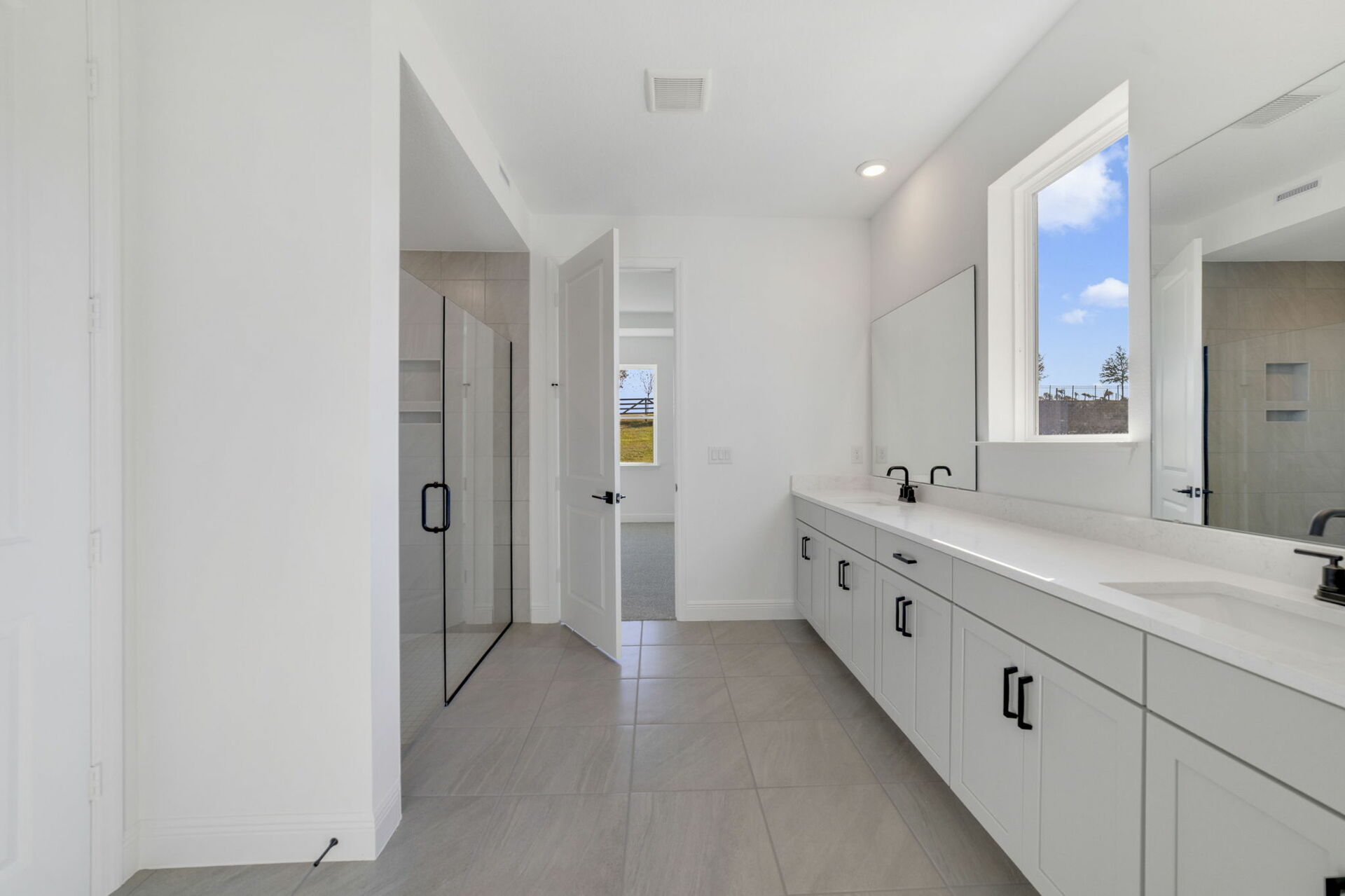 dual sink vanity with shower and access to the closet 