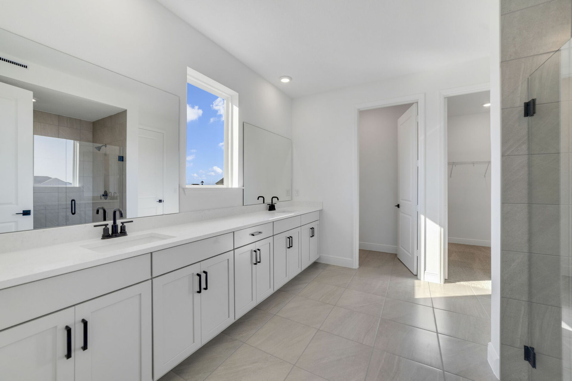 dual sink vanity with shower and access to the closet 