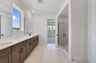primary bathroom with dual sinks, brown cabinets, and white countertops