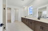 primary bathroom with dual sink vanity and brown cabinets