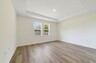 tray ceilings and hardwood vinyl plank with multiple windows. 