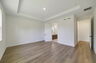 tray ceilings and hardwood vinyl plank with multiple windows. 