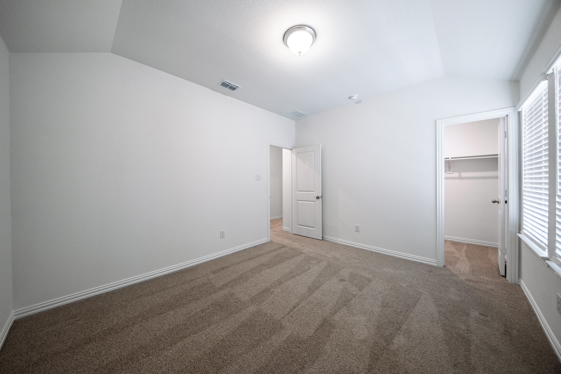 guest bedroom with carpet with walk-in closet