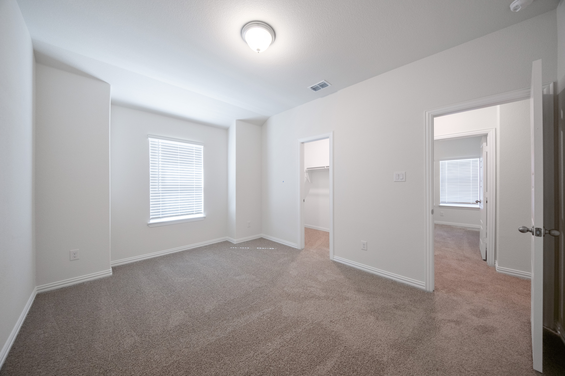 guest bedroom with carpet and walk-in closet