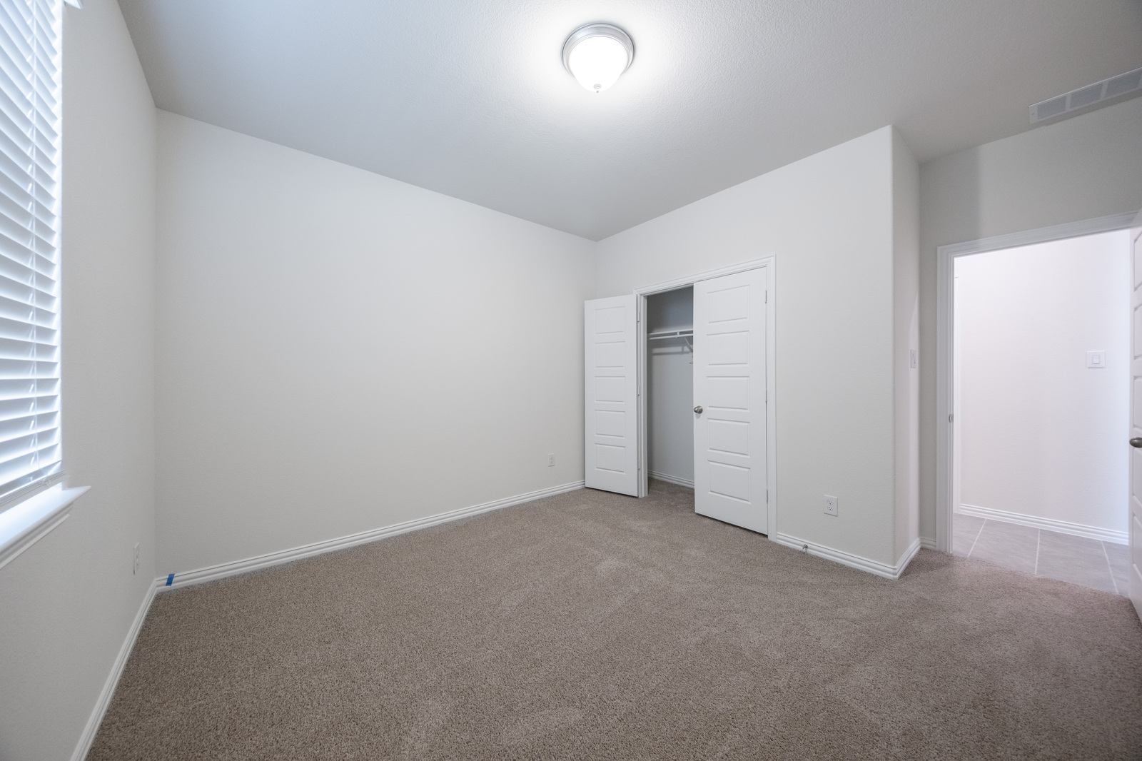 guest bedroom with carpet and window