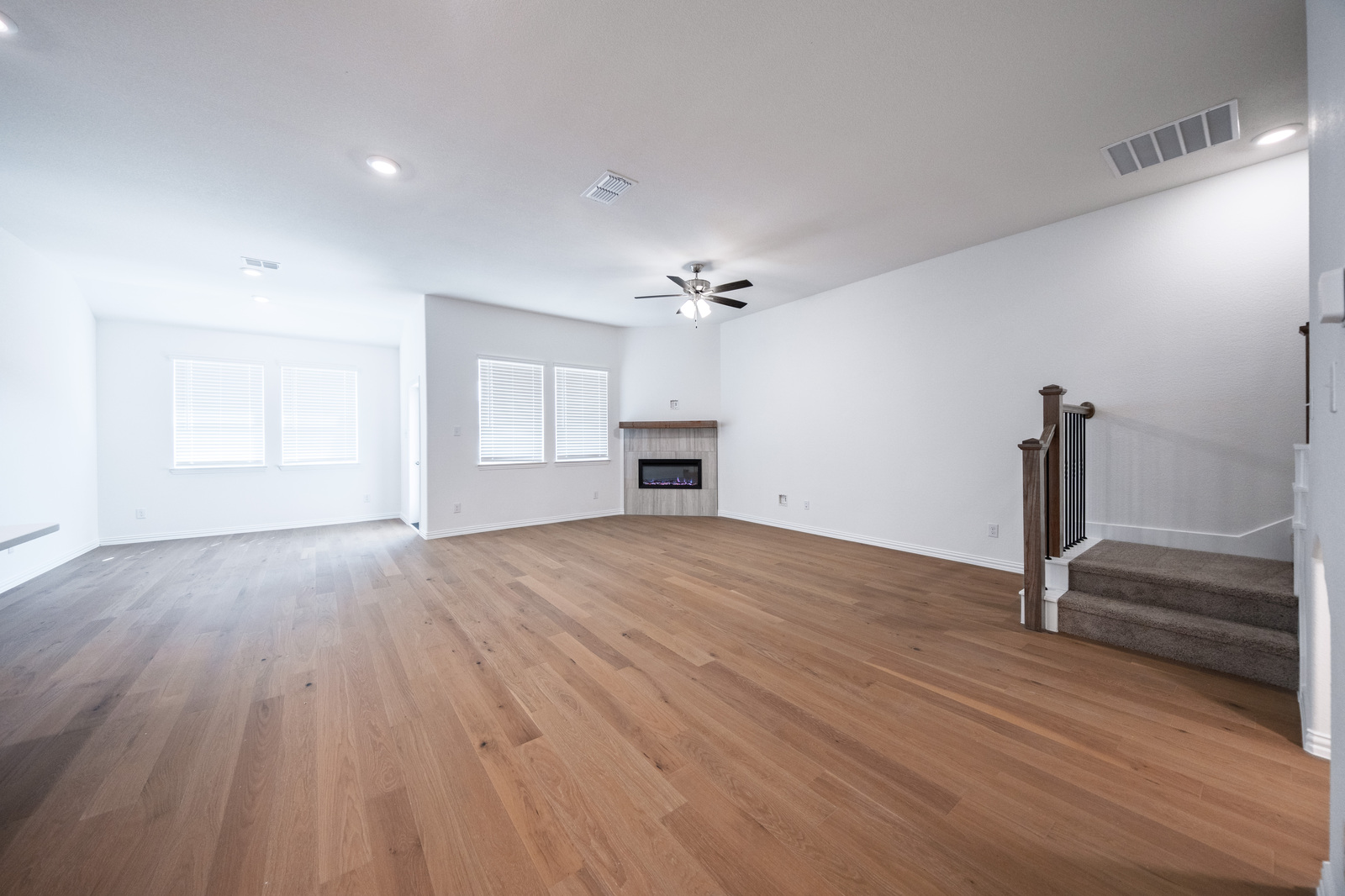 open great room with hardwood flooring and windows