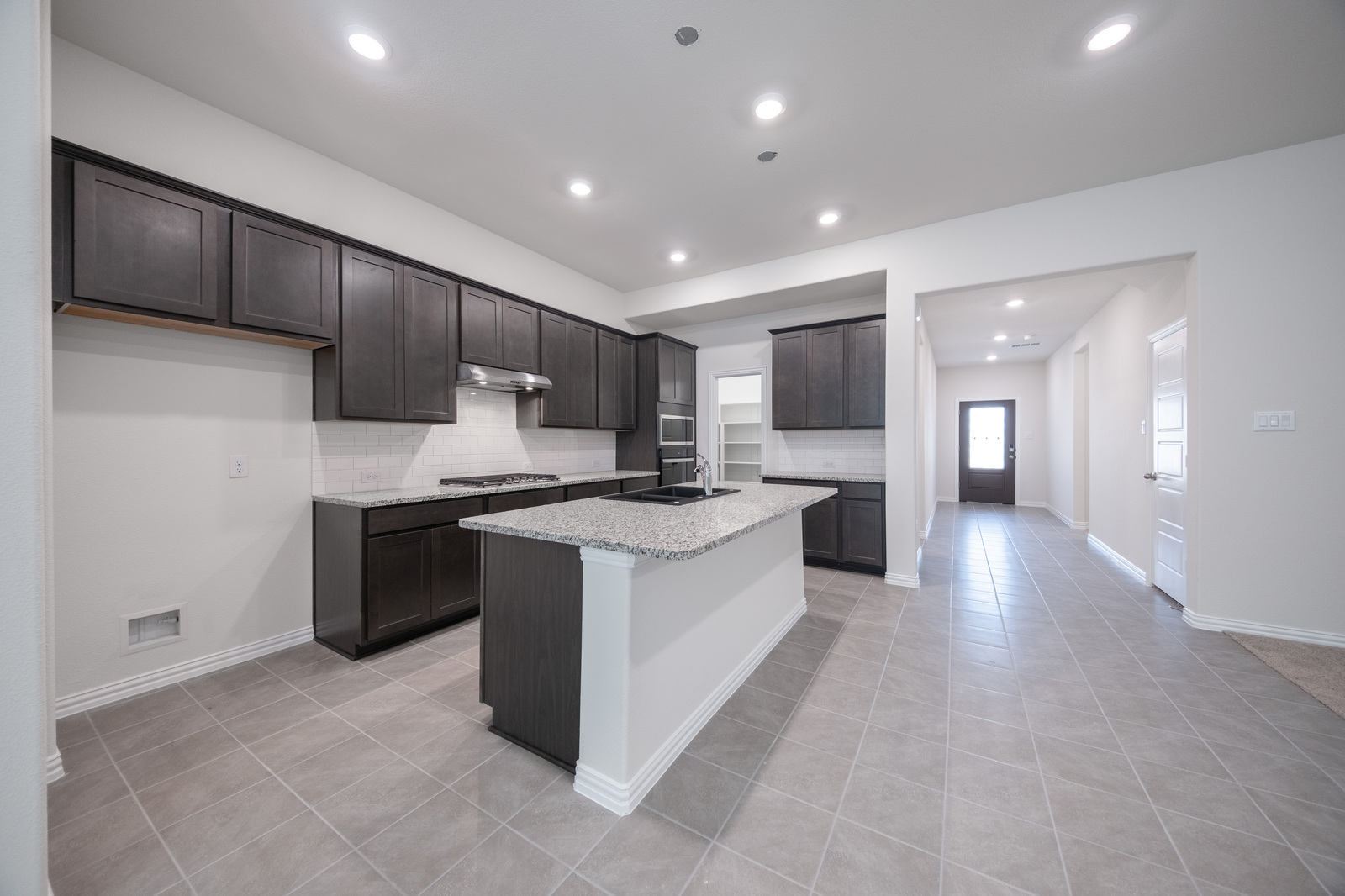 open kitchen with dark brown cabinets