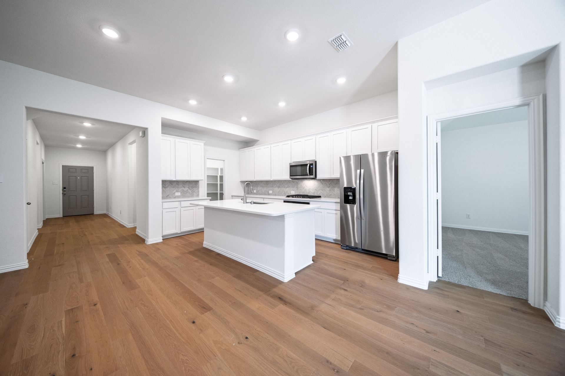 open kitchen with white cabinets and hardwood flooring
