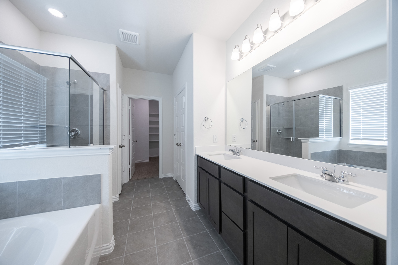 primary bathroom with tile flooring and double sinks