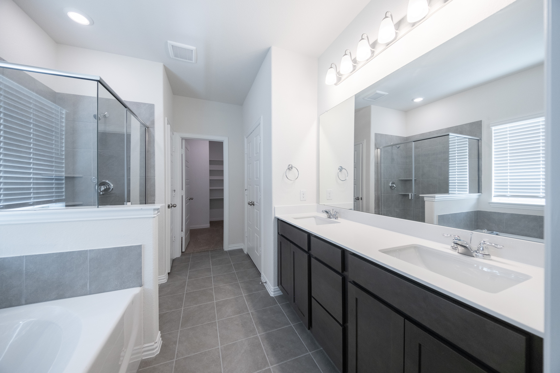 primary bathroom with tile flooring and double sinks