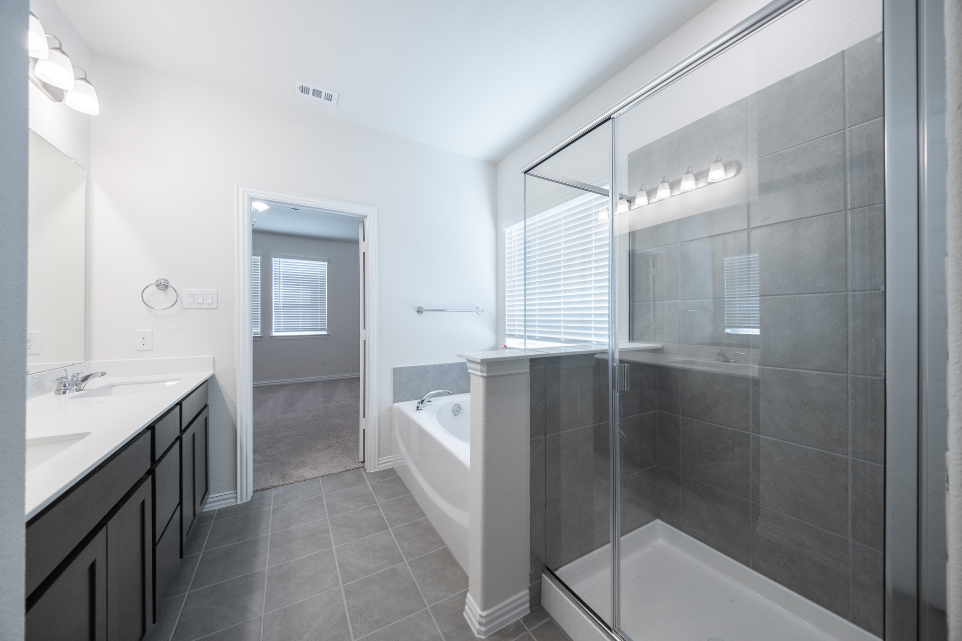spacious primary bathroom with separate soaking tub and walk-in shower