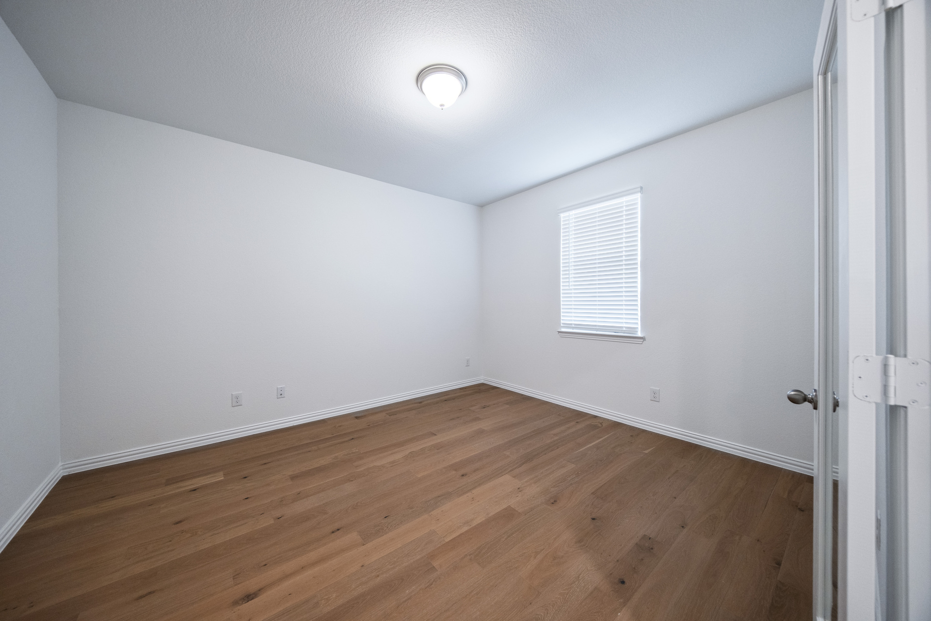 private study with hardwood flooring and window