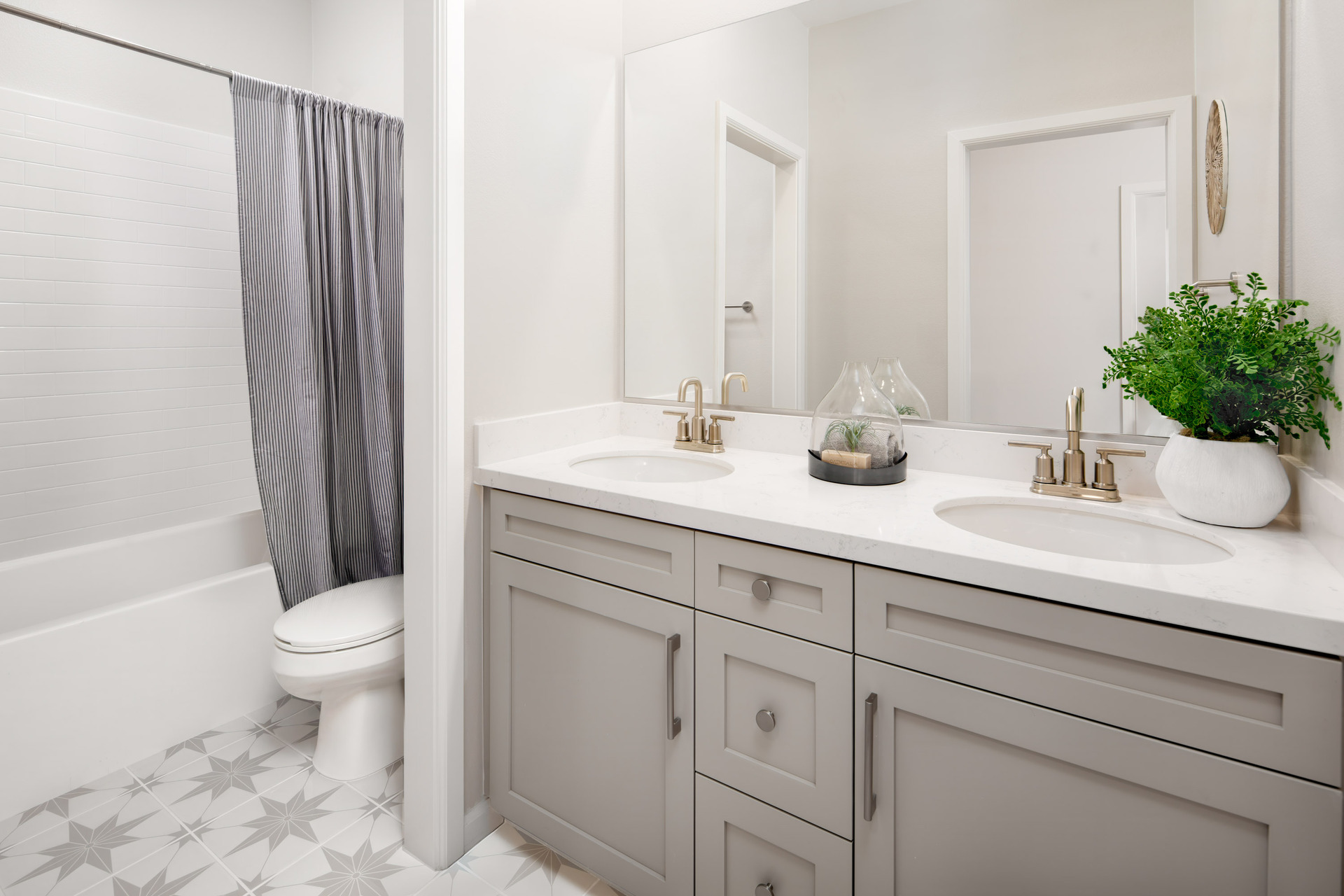 bathroom with dual sinks and tile floors