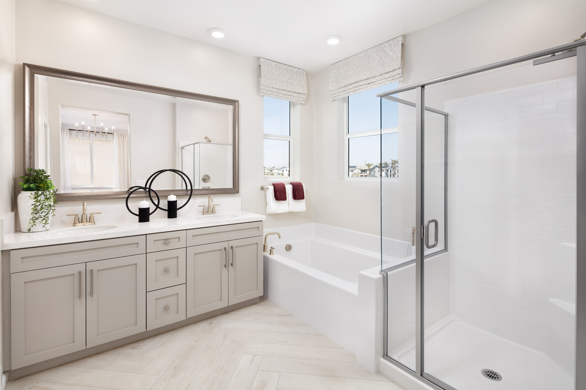 primary bathroom with large window and neutral cabinets