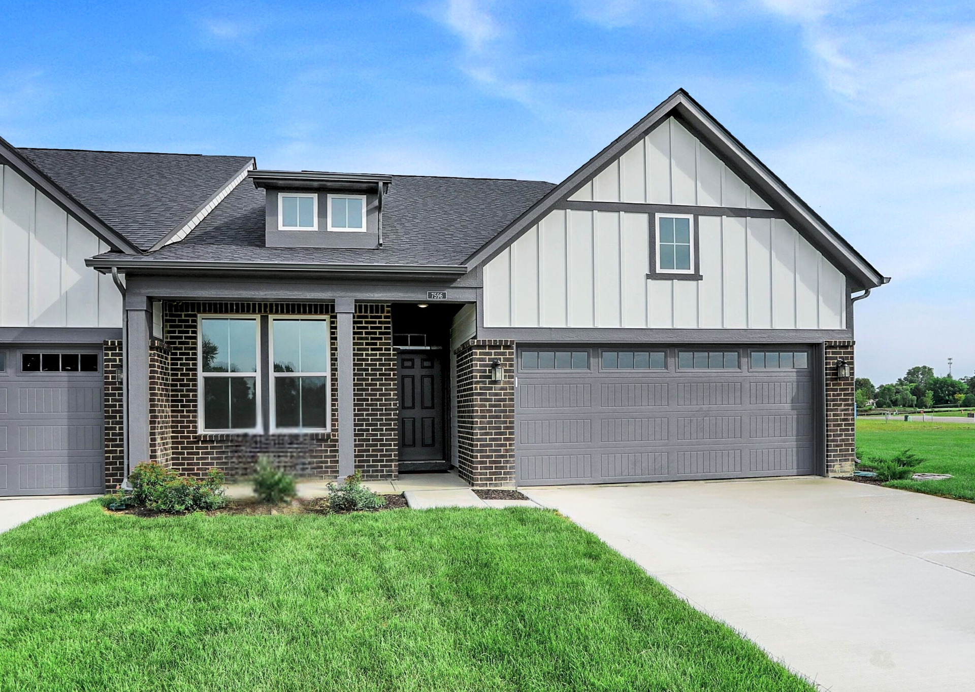 front exterior of home with black garage door and brick detail