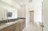 dual sink vanity with mirror, shower, and a separate tub