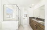 dual sink vanity with mirror, shower, and a separate tub