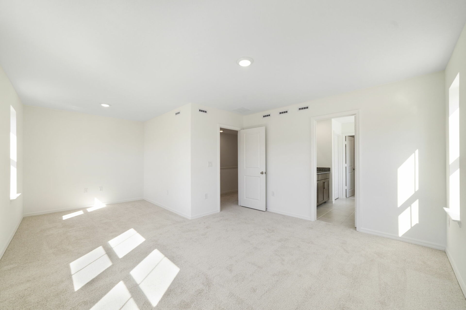 room with sitting area, carpet throughout and access to the primary bathroom