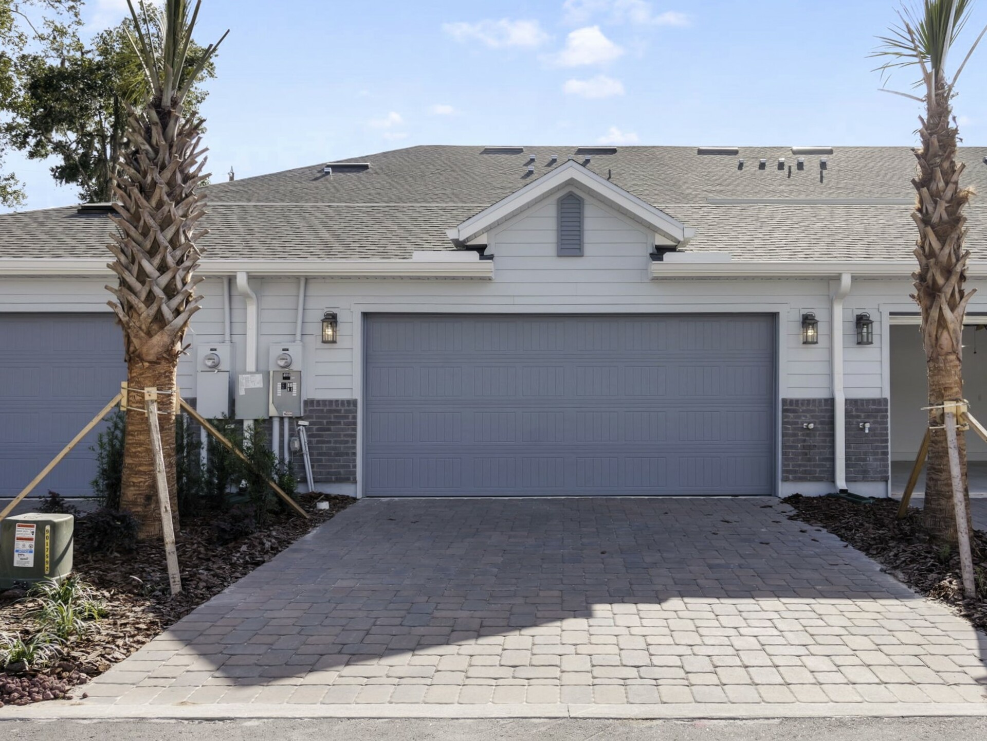 detached two-car garage with paver driveway