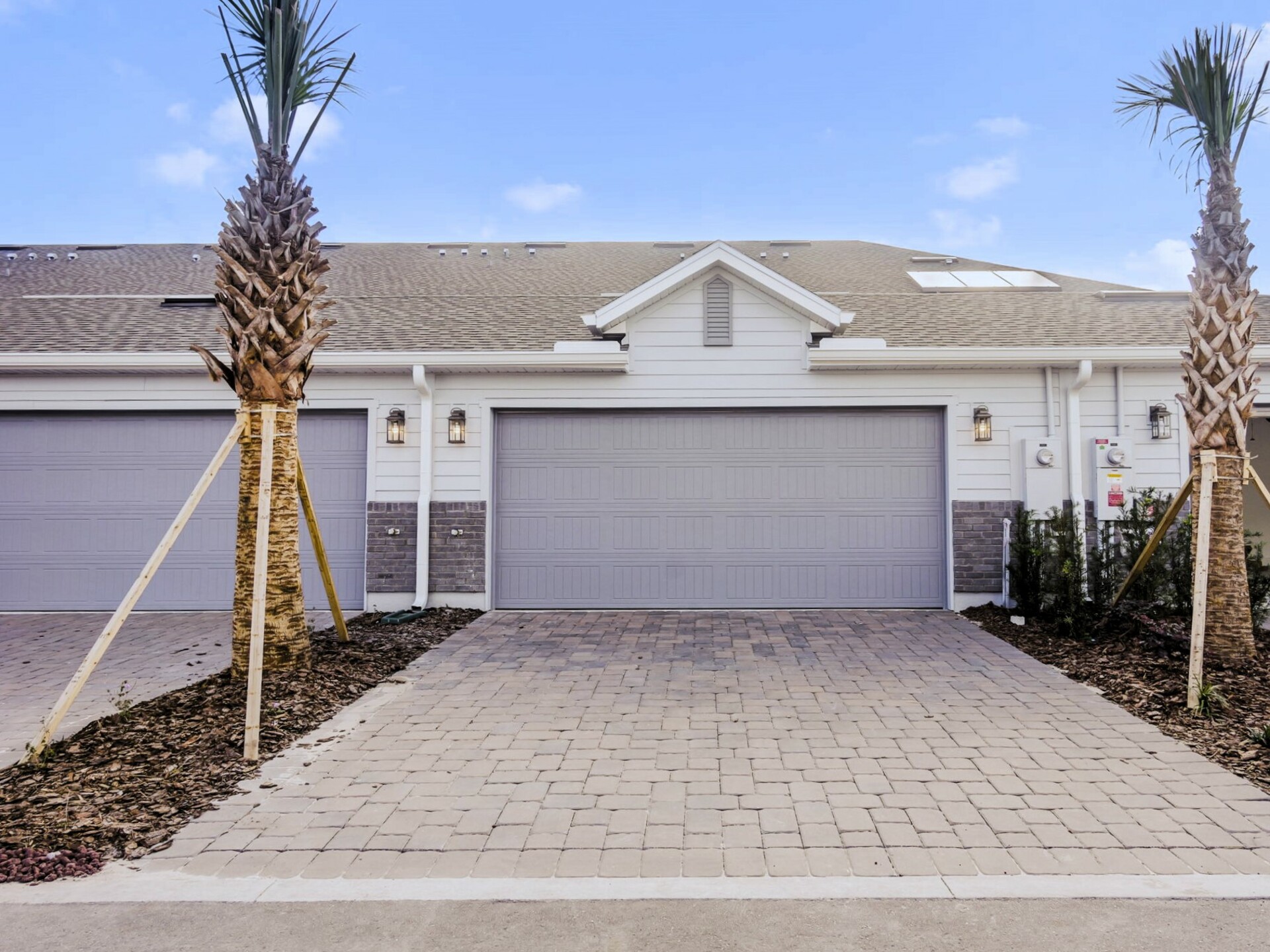 detached two-car garage with paver driveway