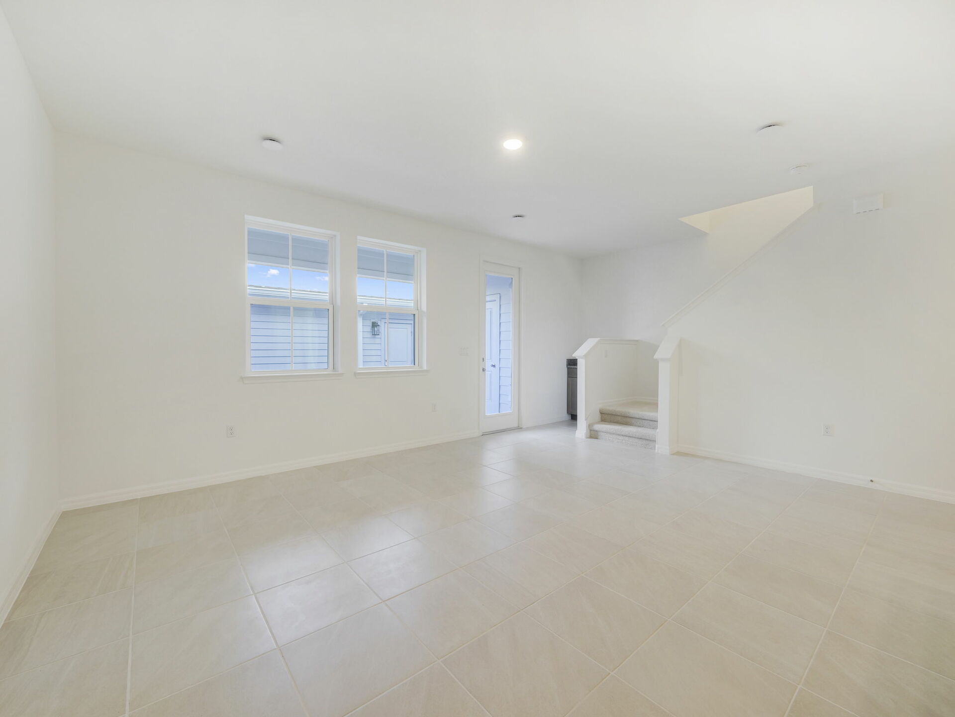 great room with tile flooring and two windows