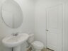 powder bathroom with mirror and white pedestal sink