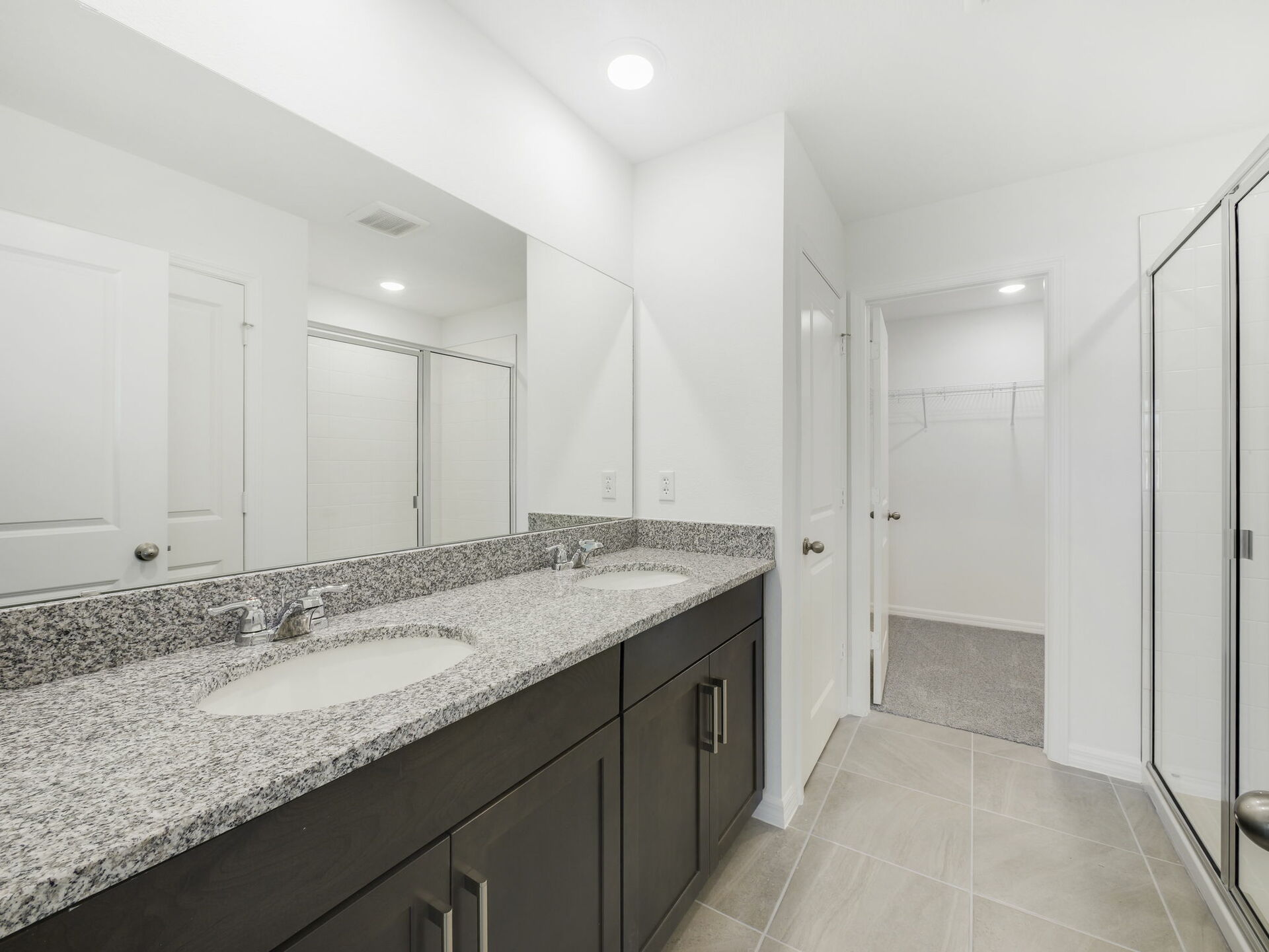 primary bathroom with dual sinks and large shower