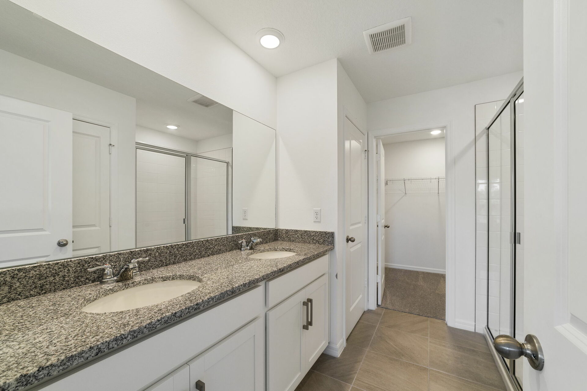 Dual sink vanity with a large mirror and shower