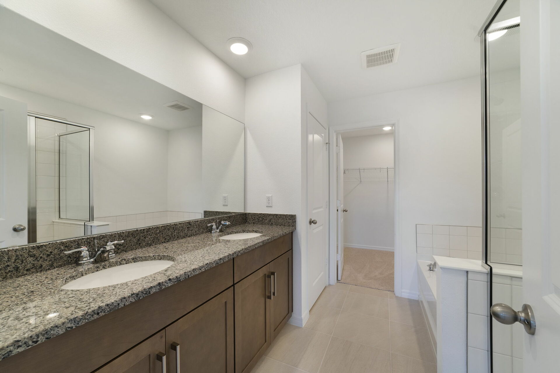 dual sink vanity with water closet, shower and tub