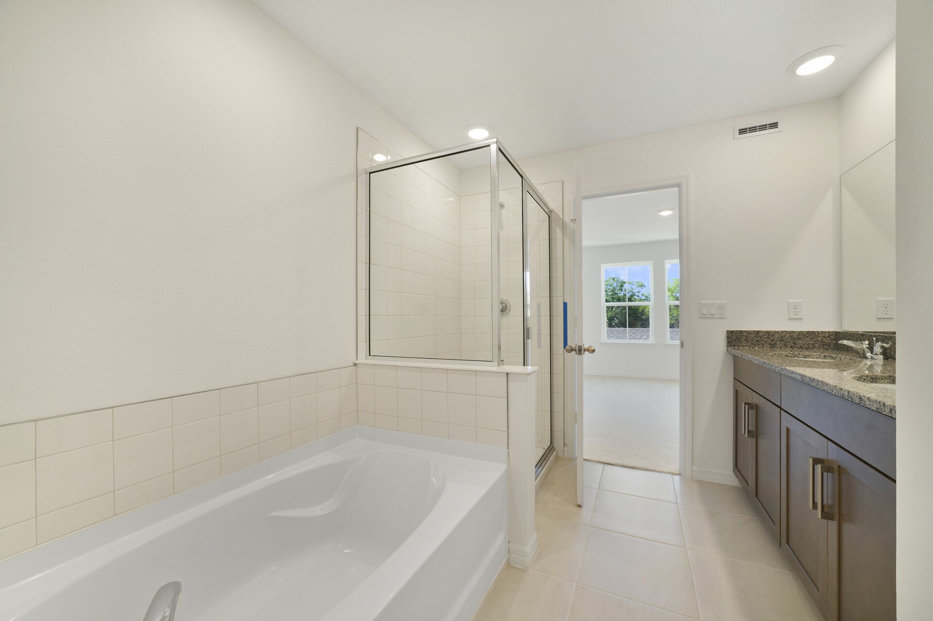 dual sink vanity with water closet, shower and tub