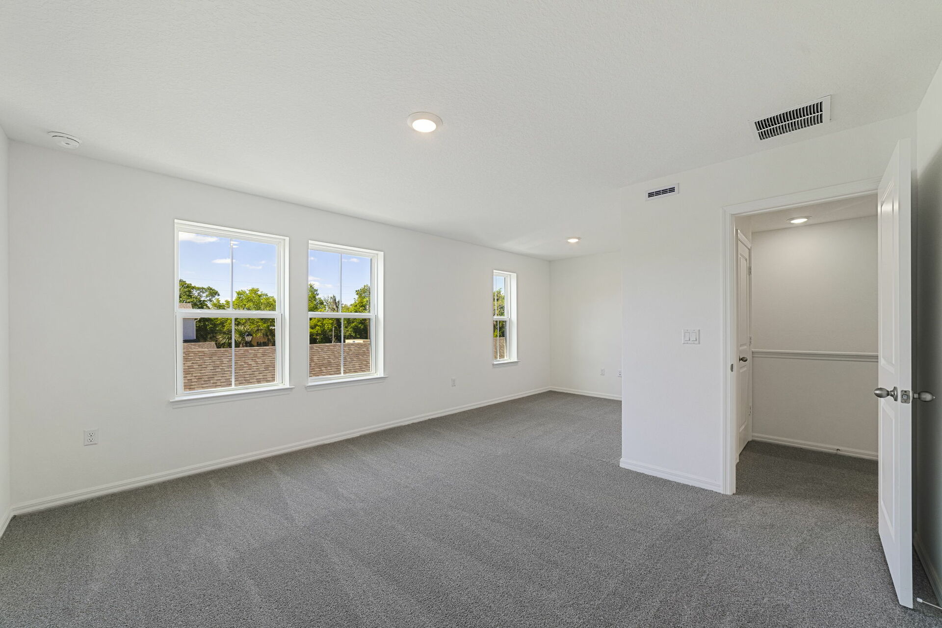 carpet throughout with a sitting room with large windows 