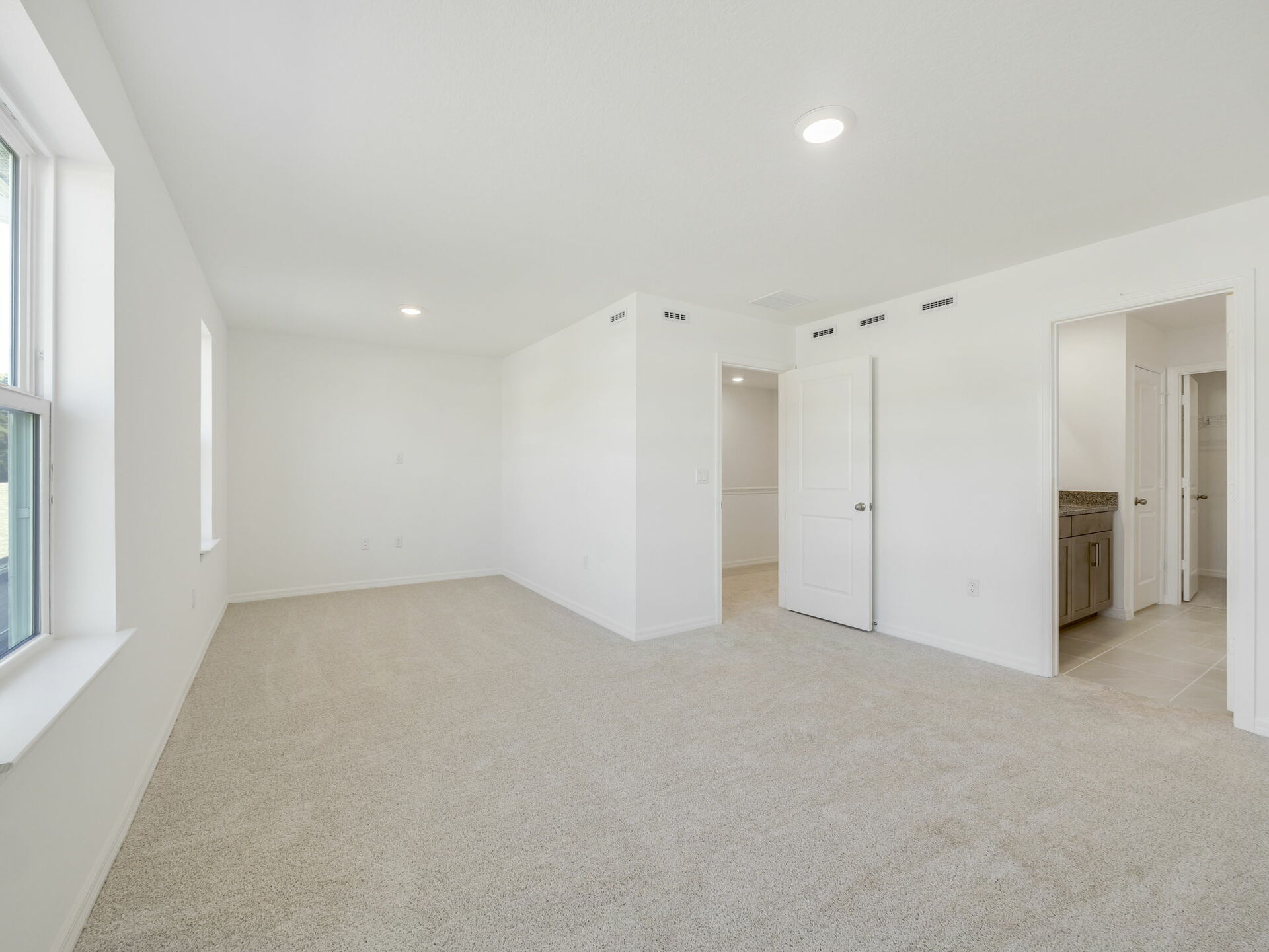 primary bedroom with carpet and sitting area
