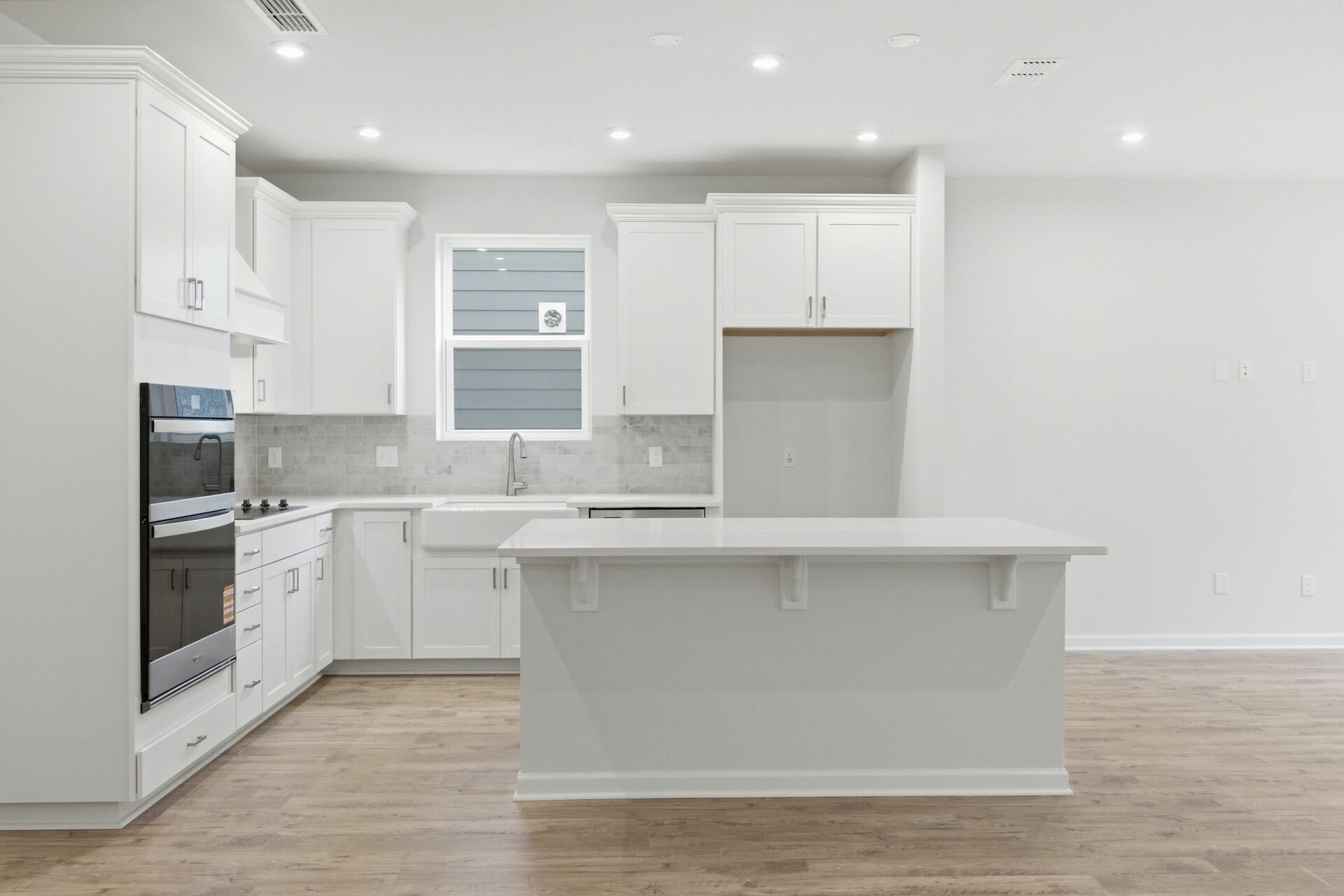 kitchen with wood flooring, white cabinets, and white countertops
