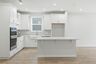 kitchen with wood flooring, white cabinets, and white countertops