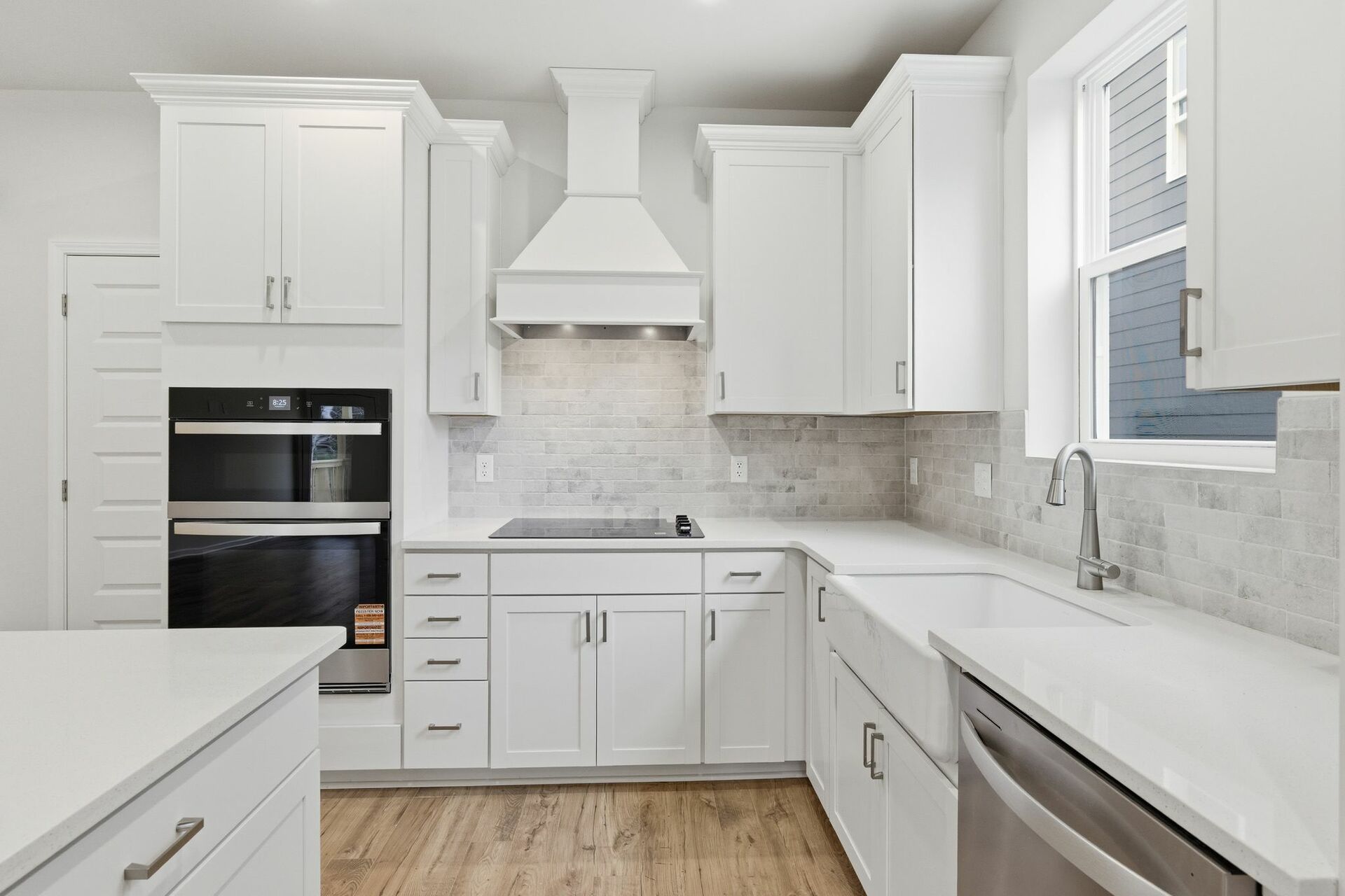 kitchen with wood flooring, white cabinets, and white countertops