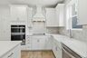 kitchen with wood flooring, white cabinets, and white countertops