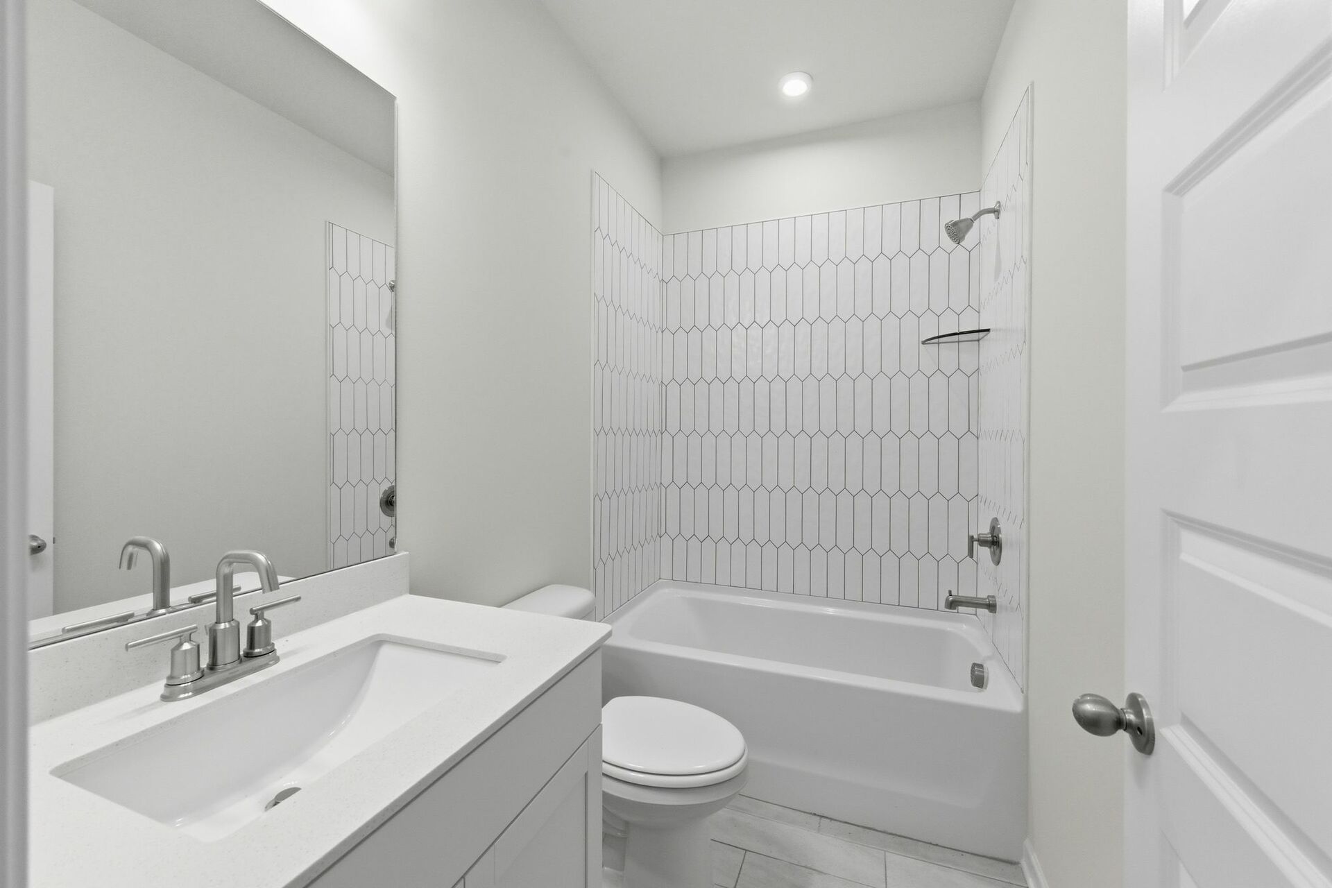 secondary bathroom with white cabinets, white countertops, and a shower and tub combination