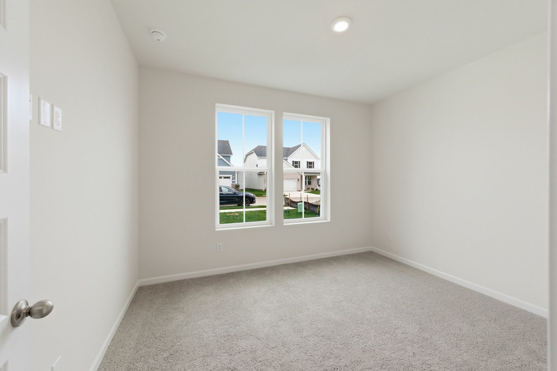 secondary bedroom with carpet flooring, white trim, and large windows