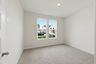 secondary bedroom with carpet flooring, white trim, and large windows