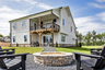 back of 2-story home with covered patio & firepit