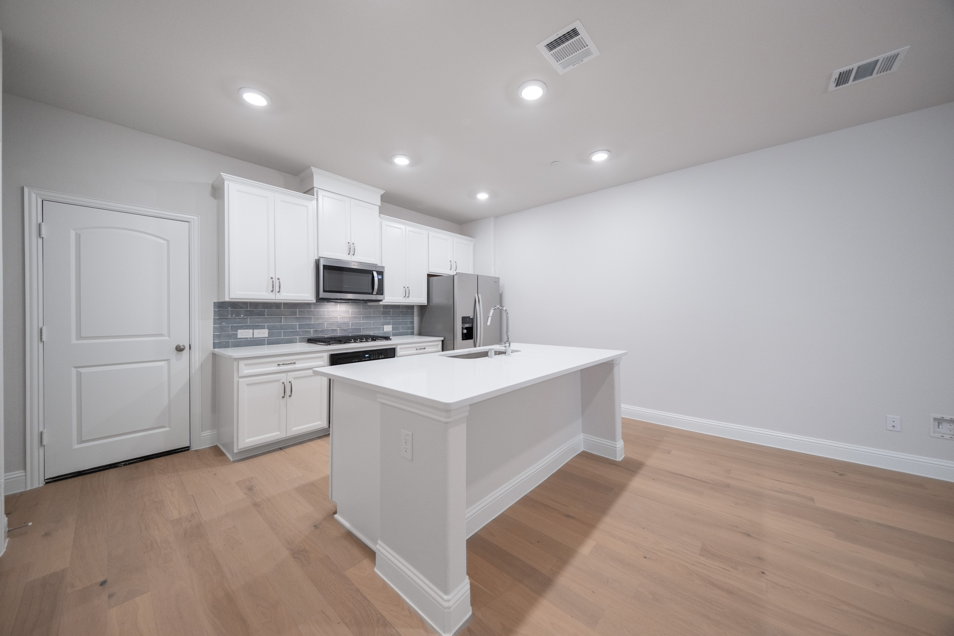open kitchen with white cabinets and hardwood flooring