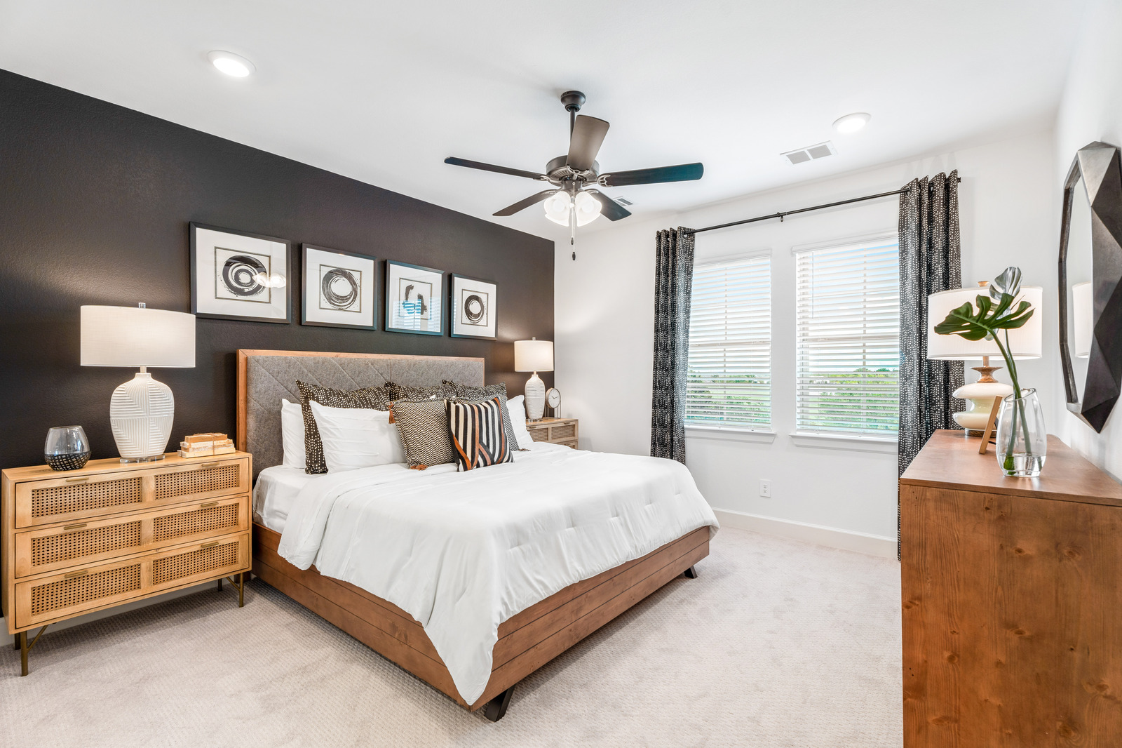 primary bedroom with large windows and carpet
