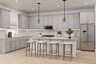 open-concept kitchen with grey cabinets and wooden barstools
