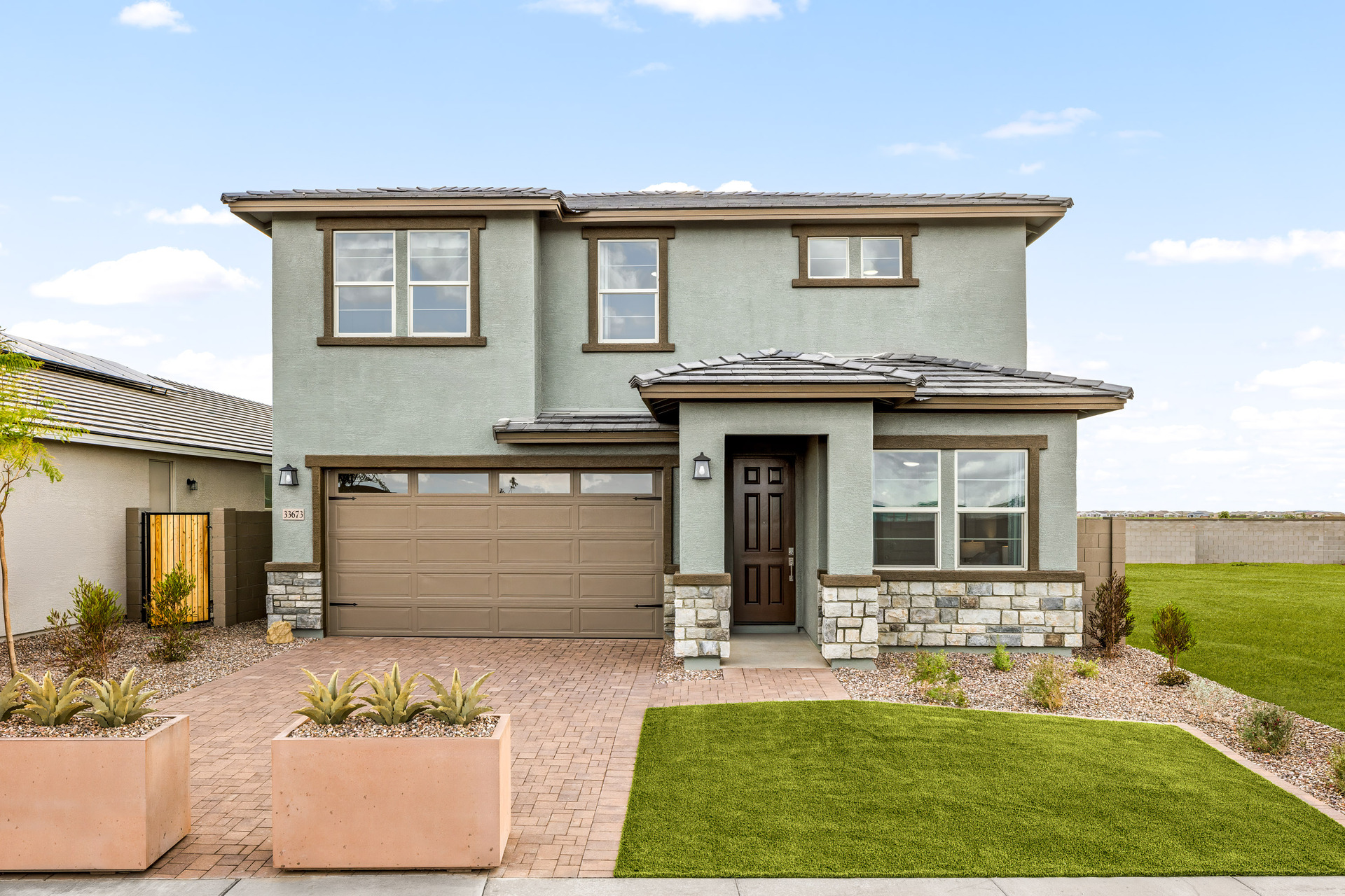 two-story home with desert landscaping and paver driveway